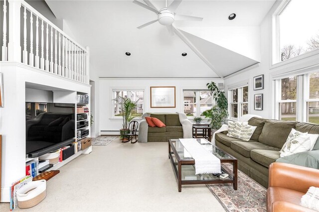 living area featuring baseboard heating, high vaulted ceiling, a wealth of natural light, and ceiling fan
