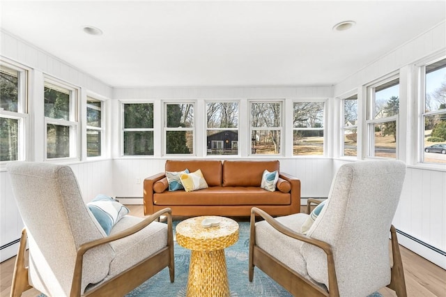 sunroom with a baseboard radiator, wood finished floors, and baseboard heating