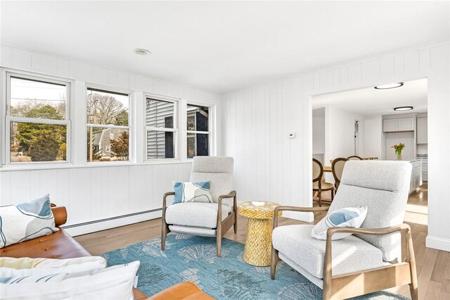 living area with a baseboard heating unit and wood finished floors