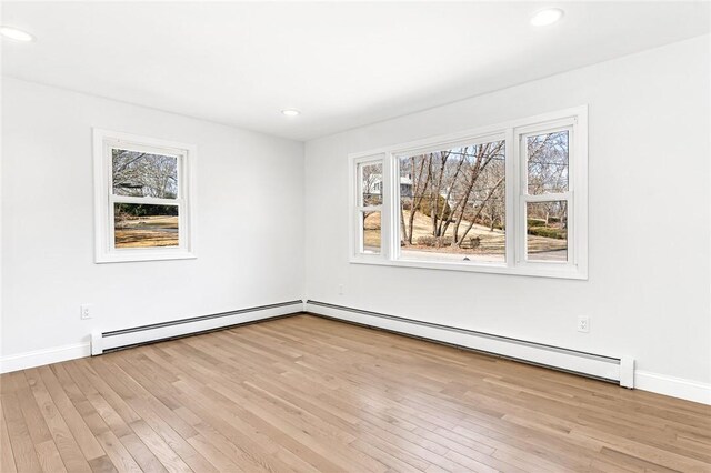 unfurnished room featuring a baseboard radiator, light wood-style flooring, and recessed lighting