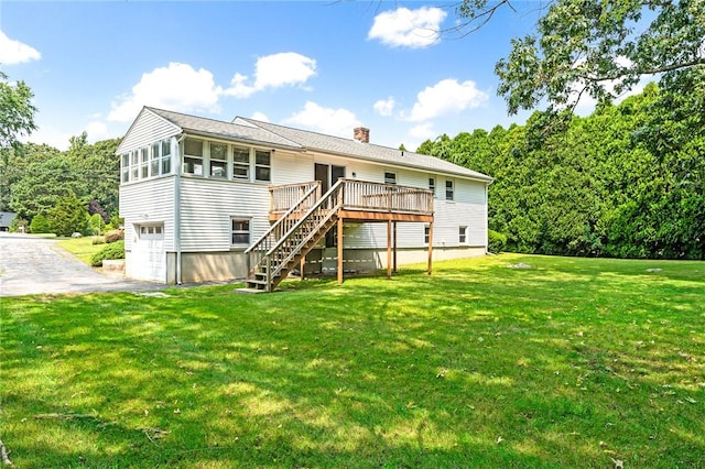 back of property featuring a chimney, aphalt driveway, stairs, a wooden deck, and a garage