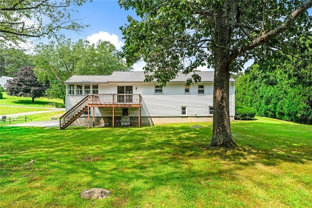 rear view of house featuring a yard, stairs, and a deck