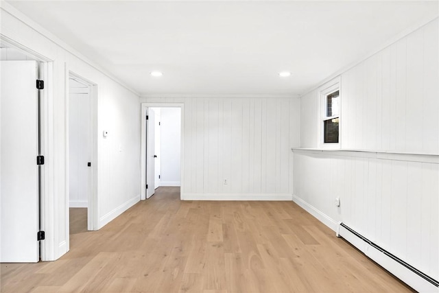 spare room with baseboards, light wood-style flooring, baseboard heating, and recessed lighting