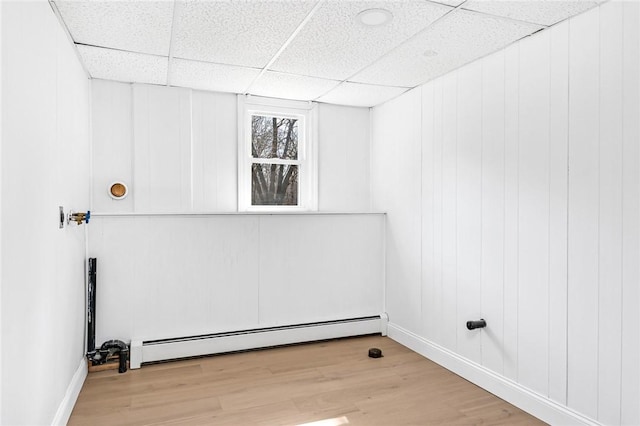laundry room featuring baseboards, light wood finished floors, and baseboard heating