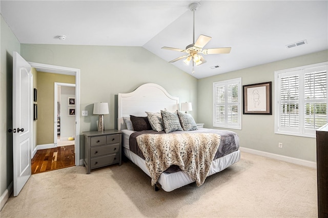 bedroom with carpet flooring, baseboards, visible vents, and vaulted ceiling