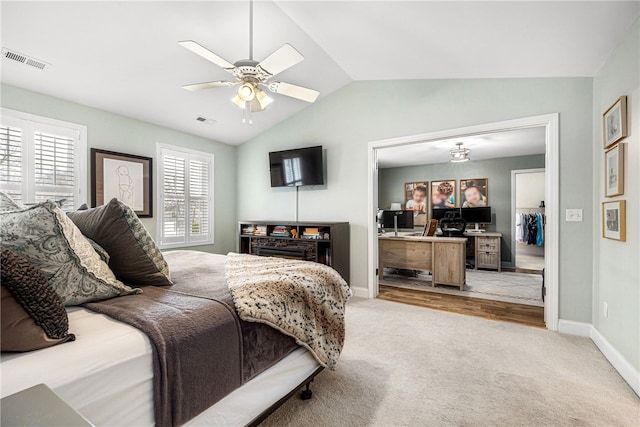 bedroom with vaulted ceiling, baseboards, light colored carpet, and visible vents
