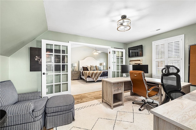 home office featuring a ceiling fan, french doors, visible vents, lofted ceiling, and light wood-style floors