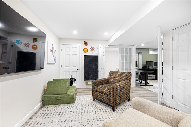 living area with baseboards, french doors, recessed lighting, and light wood-style flooring