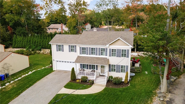 view of front of house featuring a porch, a front yard, roof with shingles, aphalt driveway, and an attached garage
