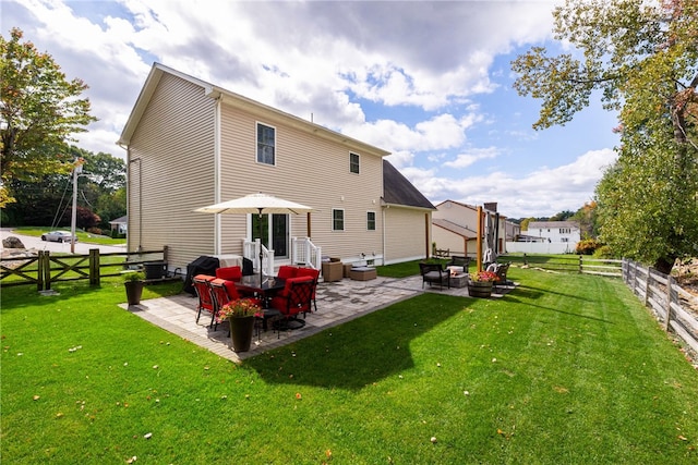 rear view of property featuring a yard, a patio, an outdoor living space, and a fenced backyard