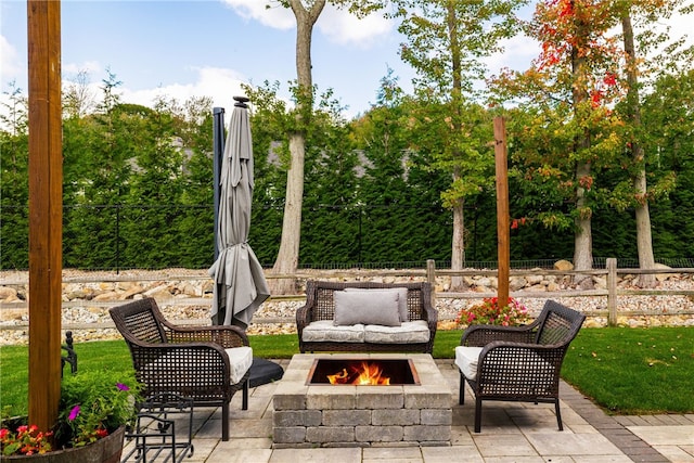 view of patio featuring fence and a fire pit