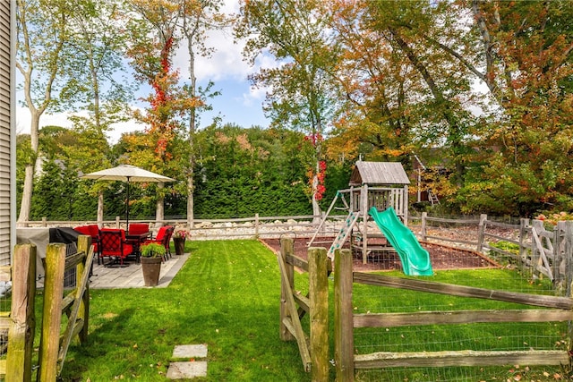 view of jungle gym with a yard, fence, and a patio area