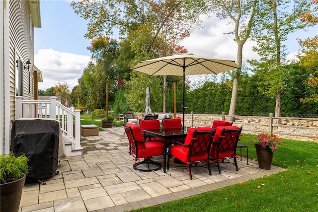 view of patio / terrace with outdoor dining area, fence, and a grill