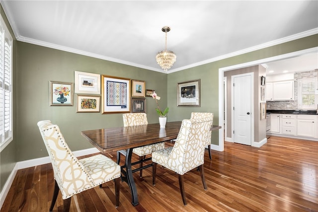 dining space featuring crown molding, baseboards, wood-type flooring, and a notable chandelier