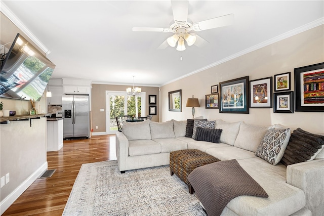 living area with baseboards, ceiling fan with notable chandelier, wood finished floors, and visible vents