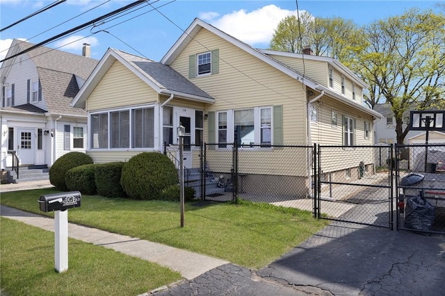 view of front of house with fence, roof with shingles, a front yard, a gate, and a chimney
