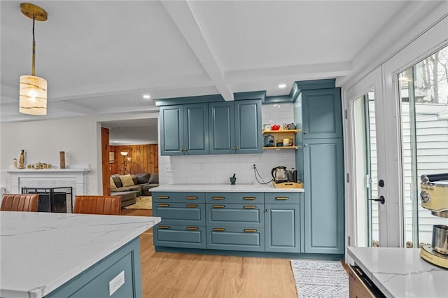 kitchen with pendant lighting, decorative backsplash, light wood-style floors, beam ceiling, and light stone countertops