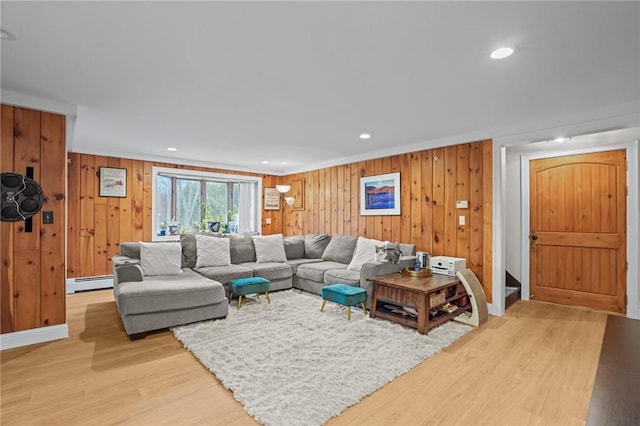 living room featuring a baseboard radiator, wooden walls, light wood-type flooring, and recessed lighting