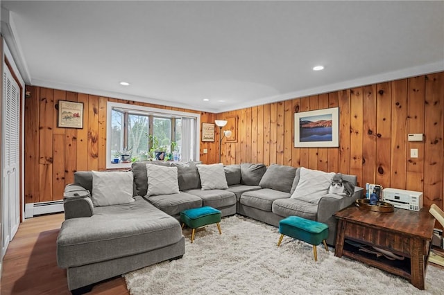 living area with recessed lighting, wood finished floors, wood walls, and a baseboard radiator