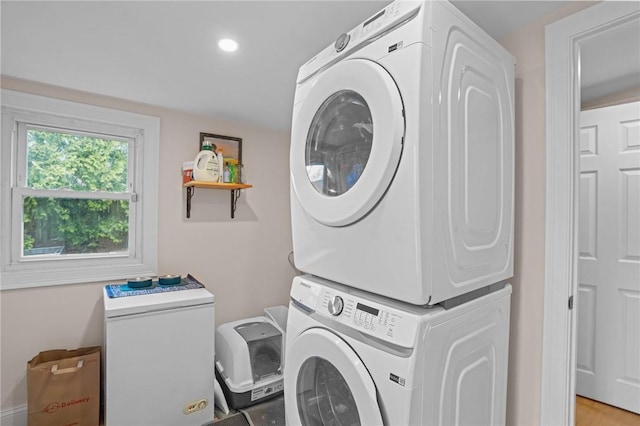 laundry area featuring stacked washer / dryer, laundry area, and recessed lighting