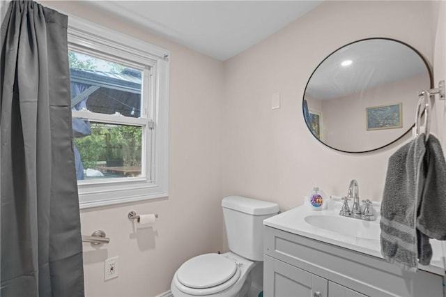 bathroom featuring vanity, toilet, and baseboards