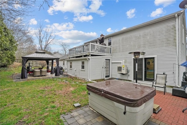back of property featuring a gazebo, a hot tub, a yard, and a patio area