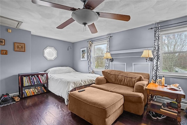 bedroom with wood finished floors, ceiling fan, and attic access