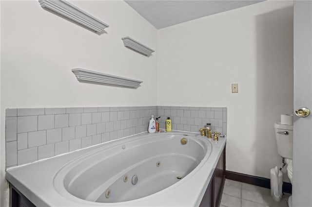 bathroom featuring tile patterned floors, toilet, a whirlpool tub, and baseboards