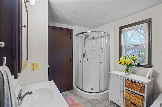 bathroom featuring tile patterned floors, a stall shower, and vanity