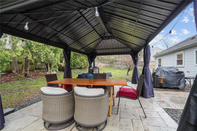 view of patio / terrace featuring a gazebo, area for grilling, outdoor dining area, and a fenced backyard