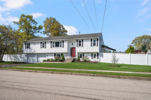 136 Wilde Field Dr, Warwick, RI 02889 - raised ranch with fence, an attached garage, driveway, and a front lawn