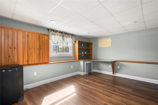 136 Wilde Field Dr, Warwick, RI 02889 - basement with baseboards, black refrigerator, dark wood-style floors, and a paneled ceiling
