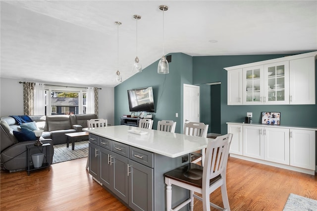 136 Wilde Field Dr, Warwick, RI 02889 - kitchen featuring a breakfast bar, open floor plan, light wood-type flooring, white cabinetry, and vaulted ceiling