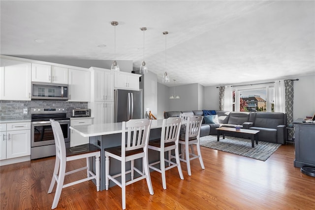136 Wilde Field Dr, Warwick, RI 02889 - kitchen featuring appliances with stainless steel finishes, tasteful backsplash, wood finished floors, and open floor plan