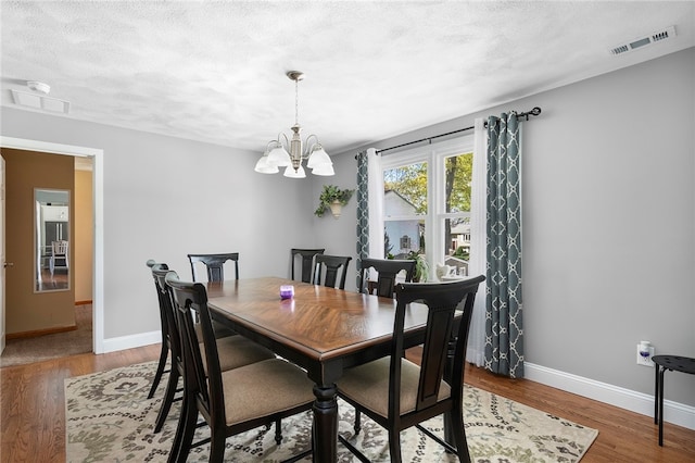 136 Wilde Field Dr, Warwick, RI 02889 - dining space featuring an inviting chandelier, baseboards, wood finished floors, and visible vents