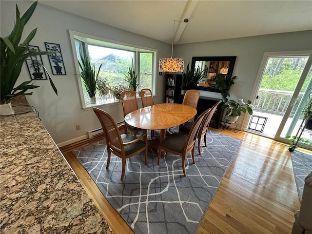 63 Duck Cove Rd, North Kingstown, RI 02852 - dining room featuring baseboards, wood finished floors, vaulted ceiling, and baseboard heating