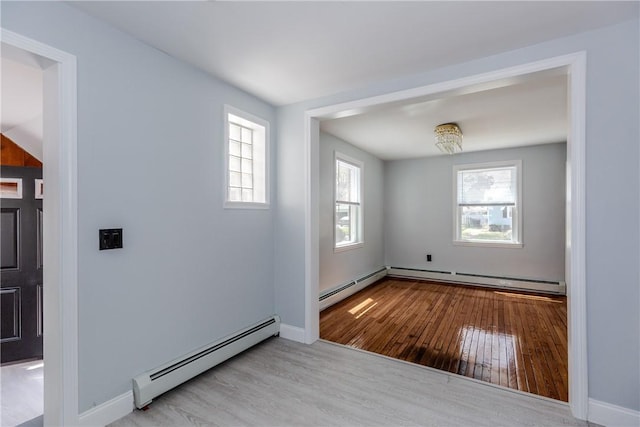 46 Freeman St, Warwick, RI 02886 - empty room featuring baseboard heating, a baseboard heating unit, a wealth of natural light, and wood finished floors