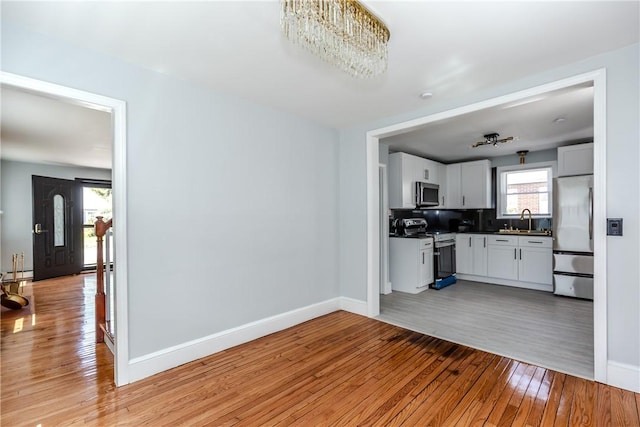 46 Freeman St, Warwick, RI 02886 - kitchen with stainless steel appliances, baseboards, dark countertops, and light wood-style flooring