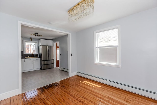 46 Freeman St, Warwick, RI 02886 - interior space featuring baseboards, a sink, baseboard heating, and light wood-type flooring