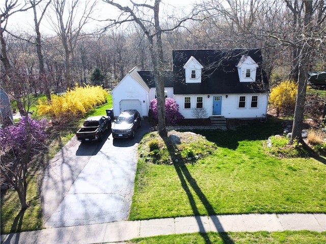 cape cod house featuring an attached garage, driveway, and a front yard