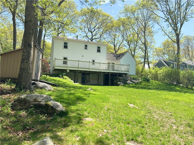 back of property featuring a wooden deck and a yard