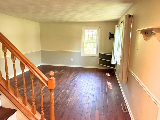 unfurnished room with hardwood / wood-style floors, stairs, and baseboards
