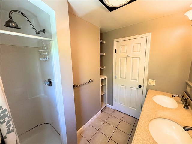 bathroom featuring a sink, a walk in shower, and tile patterned floors