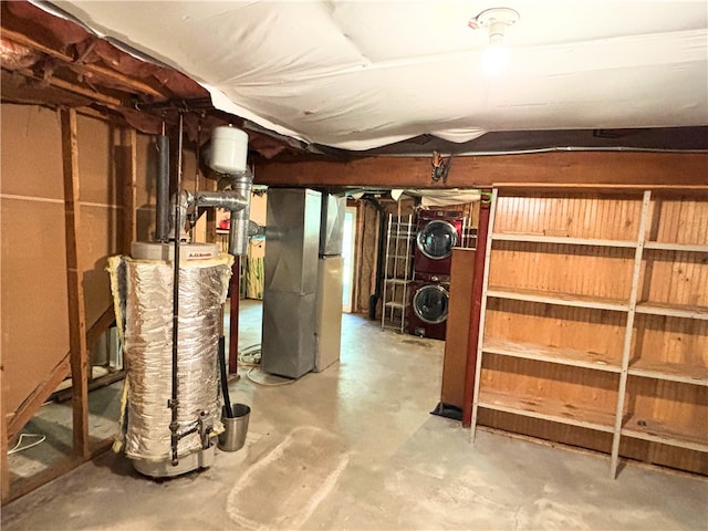 unfinished below grade area with water heater, stacked washer / dryer, and heating unit