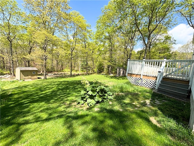 view of grassy yard with a shed, an outdoor structure, and a deck