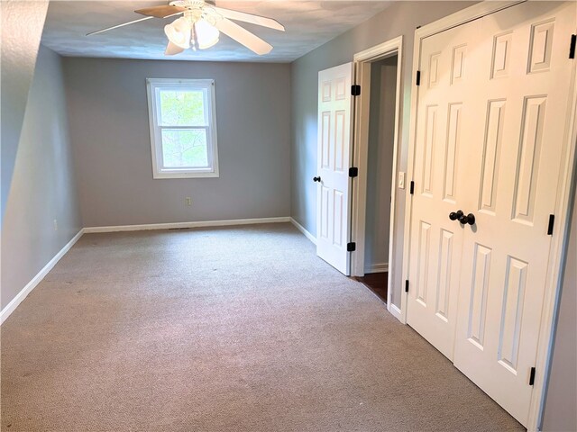 unfurnished bedroom with carpet floors, baseboards, and a ceiling fan