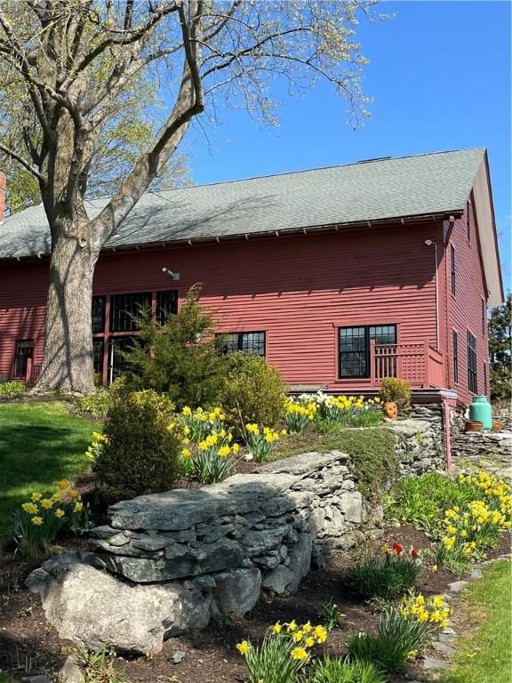 view of side of property with roof with shingles