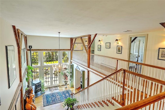 interior space featuring french doors, wood finished floors, a chandelier, and visible vents