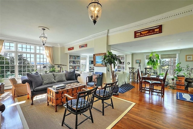 living area with ornamental molding, baseboard heating, and wood finished floors