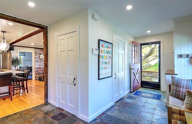 entryway with stone tile floors, recessed lighting, and baseboards